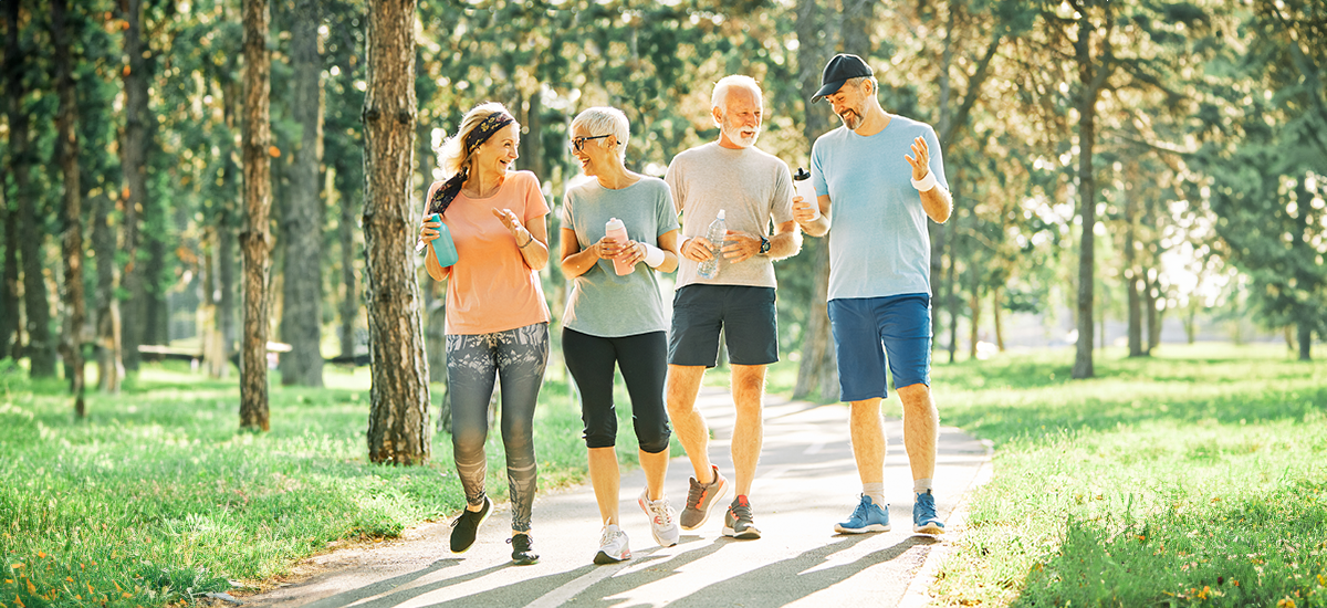 Mature friends outside walking talking about hearing health.