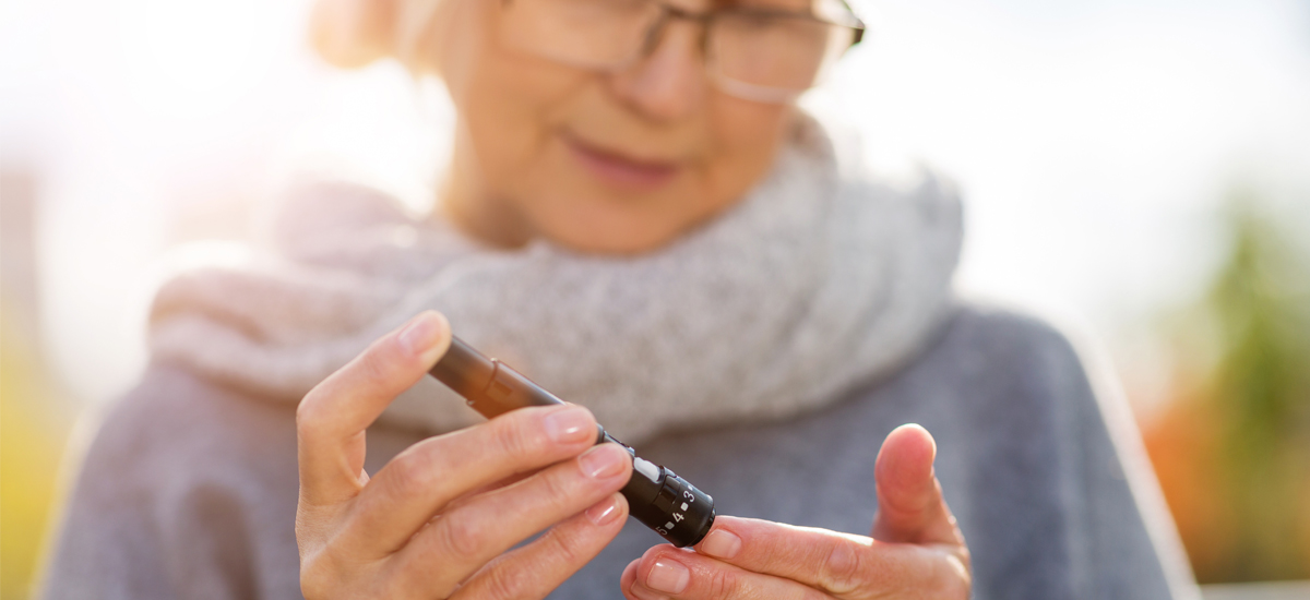 Mature woman using a glucose monitor to check her blood